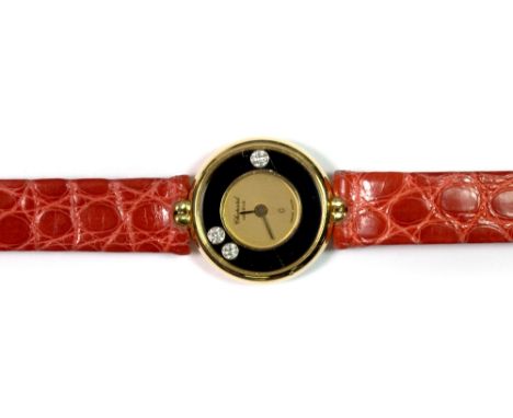 A ladies 18ct gold Chopard wristwatch with "floating diamond" face and red leather strap.