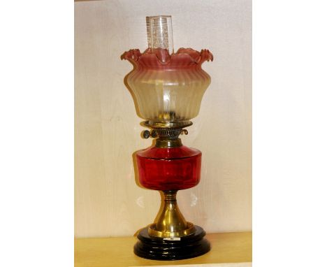 A Victorian cranberry glass oil lamp, H. 55cm.