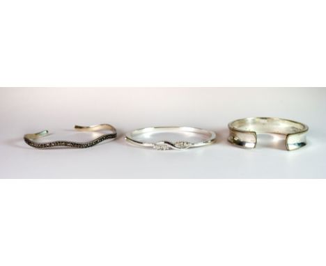 Two silver bangles and one white metal bangle.