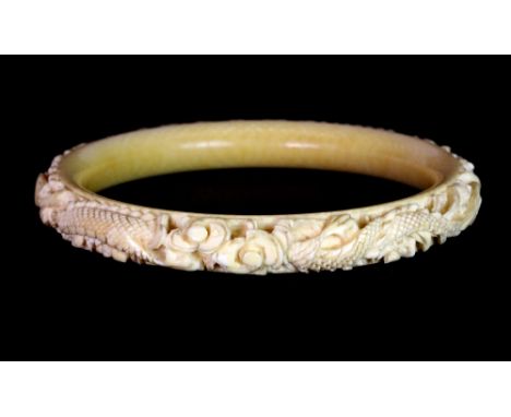 A 19th century Chinese carved ivory dragon bangle, Dia. 9cm.