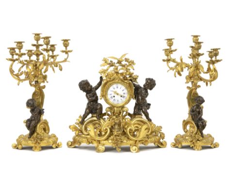 19th Cent. French Louis XV style garniture in gilded bronze adorned with cupids in bronze with a darkbrown patina : a pair of