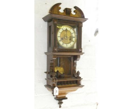 A GERMAN WALNUT AND STAINED SOFTWOOD WALL CLOCK WITH PRIMROSE ENAMEL CHAPTER RING