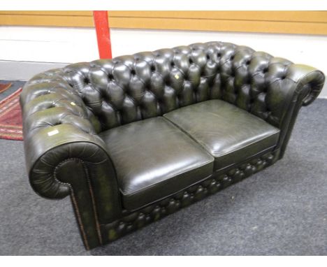 A green leather chesterfield-style two-seater sofa