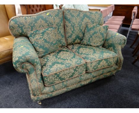 A good quality modern two-seater sofa in green floral fabric