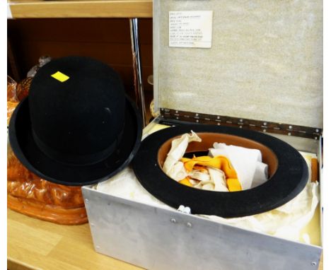 A boxed bowler hat with accessories together with another bowler hat