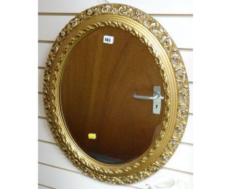 A good oval bevelled glass mirror in an ornate gilt frame