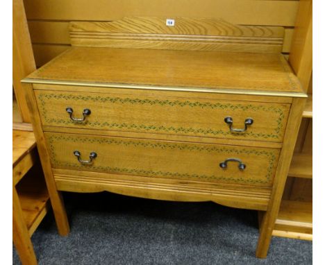 A vintage light oak two-drawer railback chest of drawers with painted decoration