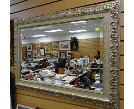 A large modern ornate gilt framed bevelled glass wall mirror
