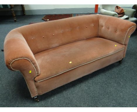 A vintage pink upholstered chesterfield-type button back settee