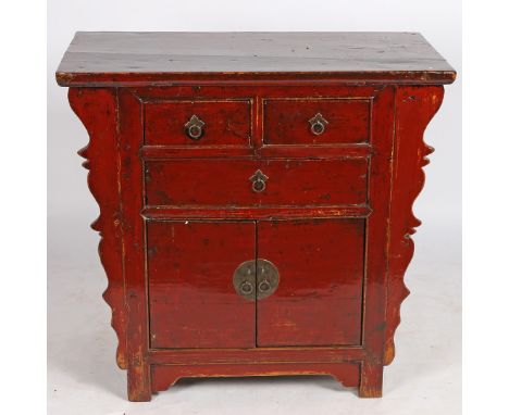 A 20th century Chinese red painted cabinet, having a rectangular top above three drawers and a pair of cupboard doors, and ha