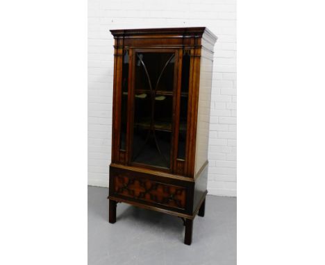 Mahogany cabinet with dentil cornice over an astragal glazed door opening to reveal a shelved interior, over a single carved 