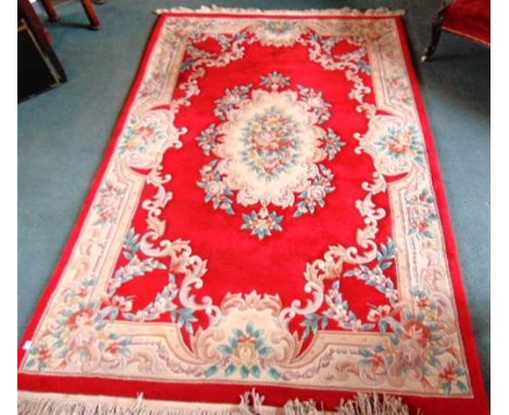 A RED GROUND CHINESE CARPET  with typical floral patterned decoration, 183cm x 276cm