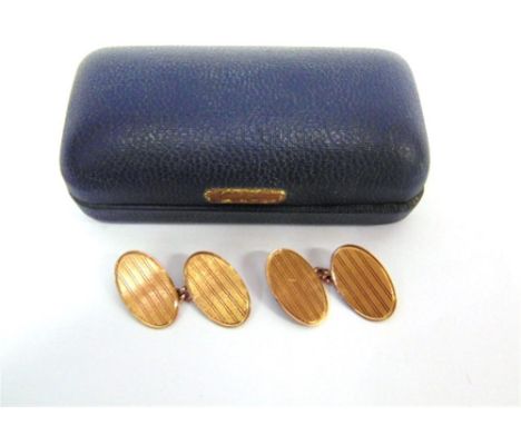 A PAIR OF 9 CARAT GOLD CUFFLINKS the oval panels with linear engine turned decorations with chain connectors, 5.9g gross, cas