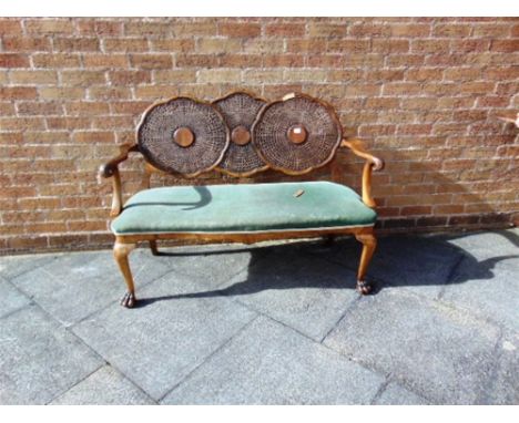 A CARVED WALNUT BERGERE SOFA  with serpentine front upholstered seat on carved cabriole supports with claw and ball feet, 126