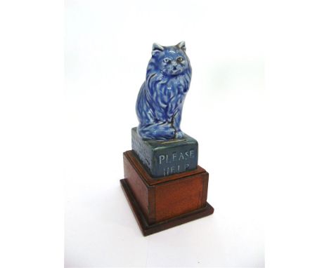 AN RSPCA CERAMIC CHARITY BOX,  modelled as a seated cat on box inscribed 'PLEASE HELP THE ROYAL SOCIETY FOR THE PREVENTION OF