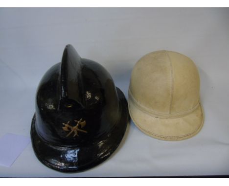 Vintage motor cycle helmet made by Aviarit and a vintage fireman's helmet made by Levior Belgium