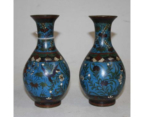 A pair of Chinese cloisonne enamel vases, each decorated with birds amongst flowers, h.18cmOne has a large knock to the side.