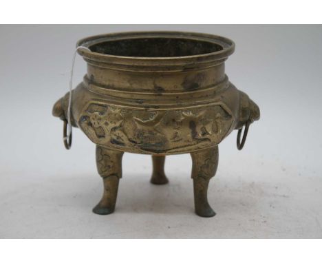 A Chinese brass tripod censer, flanked by zoomorphic handles, zhuanshu seal mark to the underside, width 17cm