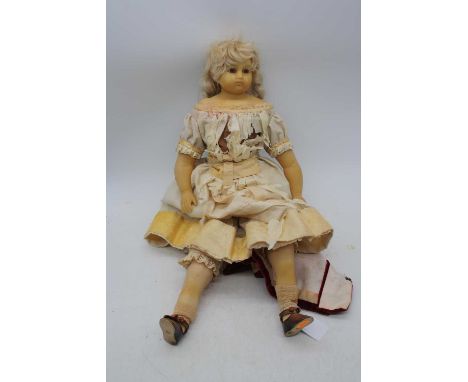 A 19th century wax doll, having glass eyes and adjustable limbs, 50cmThe clothing is in tatters. The wax seems generally inta
