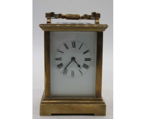A large early 20th century lacquered brass cased carriage clock having an enamelled dial with Roman numerals, visible platfor
