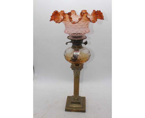 A Victorian brass oil lamp, the amber tinted shade above an amber tinted font and corinthian column stem, height 64cmNo drill