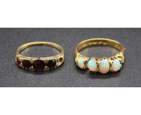 An 18ct gold cabochon opal four stone dress ring, 3.5g, size P (a/f); together with a 9ct gold garnet set dress ring, 2.3g (a