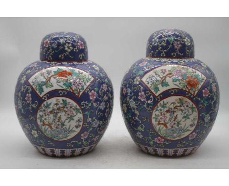 A pair of Chinese export jars and covers, each of globular form, on a blue ground with opposing panels enamel decorated with 