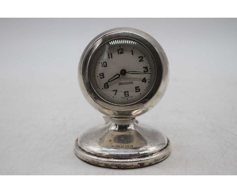 An early 20th century travel clock having a white enamel dial with Arabic numerals signed Meccedes within a silver case on lo