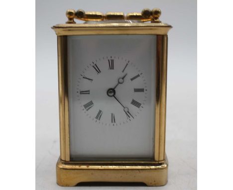 A 20th century lacquered brass cased carriage clock having an enamel dial with Roman numerals, visible platform lever escapem