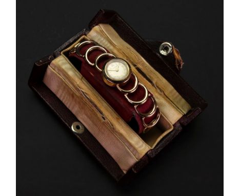 Jaeger Le Coultre; a lady's 9ct gold wristwatch, the circular white dial with applied gilt metal Arabic numbers, to a manual 