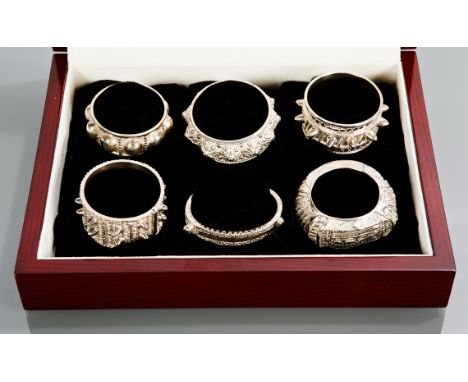 SET OF SIX OMANI SILVER BANGLE STYLE NAPKIN RINGS each of a different design , in a fitted case from Jawahir Oman jewellers