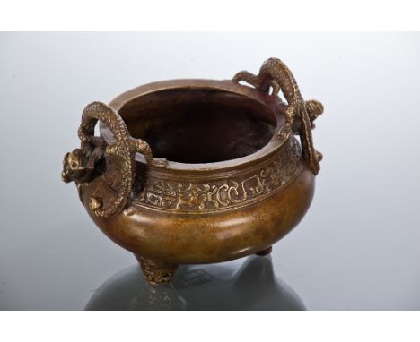 CHINESE BRONZE CENSER  of bombe form, with twin dragon handles, with a stylised band below the rim and on tripod feet with ru