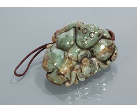 CHINESE JADE CARVING in green tones and showing a Buddha to the front, 8cm long 
