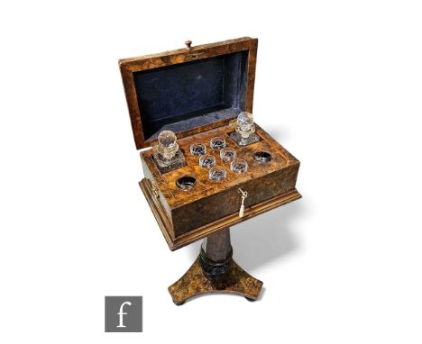 A 19th Century burr walnut decanter stand, the caddy top opening to reveal a compartmentalised interior, later decanters and 