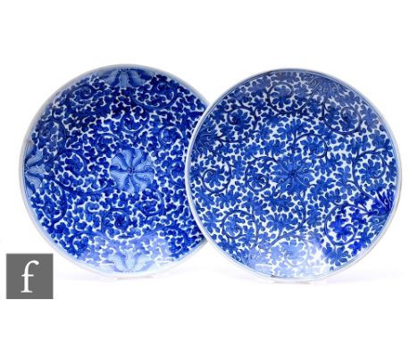 A pair of Kangxi style blue and white chargers, decorated with central lotus designs with meandering tendrils, diameter 38cm.