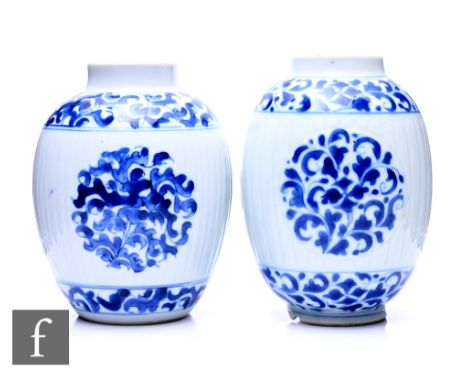 A matched pair of Chinese Kangxi period (1661-1722) blue and white ovoid form vases, each of ribbed form, decorated with blue