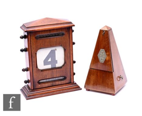 An Edwardian walnut table top calendar with scroll adjustment on stepped base, height 27cm, and a Maelzel metronome. (2) Cond