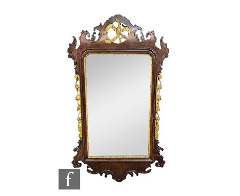 A 20th Century Chippendale style parcel gilt wall mirror, the pediment pierced with a Ho Ho bird, 102cm x 59cm, and a similar