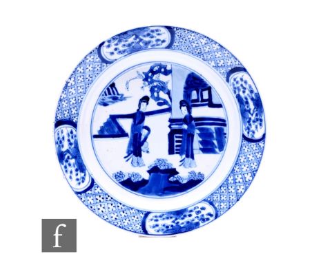 A Chinese blue and white Kangxi period dish, of circular form, decorated with figures amongst formal gardens, Chenghua (1465-