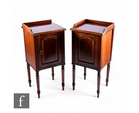 A pair of Edwardian style mahogany gallery bedside cabinets, the shelf interior enclosed by a pair of crossbanded arch shaped