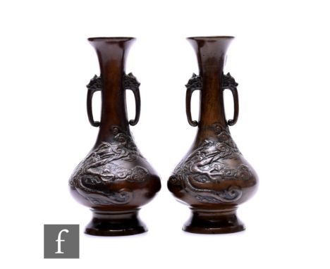 A pair of Japanese late Meiji Period (1868-1912) bronze vases, each of bottle form, with relief cast dragon designs, heights 