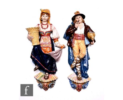 A pair of Ginori majolica wall figures, circa 1900, modelled as male and female figures, dressed in traditional costume, the 