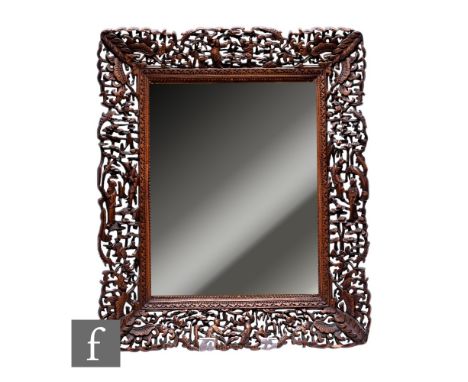 A 20th Century Chinese carved hardwood framed mirror, the pierced frame decorated with manchu figures, cicada and butterflies