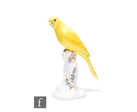A Royal Worcester porcelain figure of a canary, circa 1955, modelled perched on a tree stump with painted blue flowers and le
