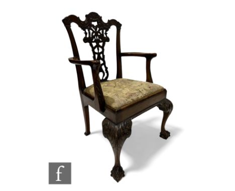 A 19th Century Chippendale style carved mahogany elbow chair, pierced bow splat below an undulating top rail on carved cabrio