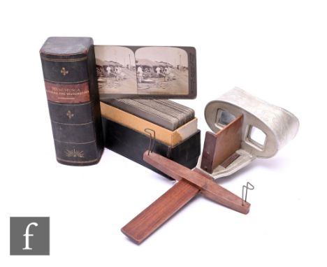 A hand held wooden stereoscopic viewer, with a collection of cards in a book form case, 'Manchuria, Through the Stereoscope'.