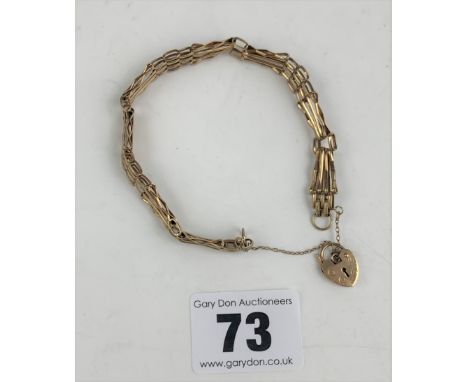9k gold gate bracelet with heart lock, 8” long. W: 6.6 gms