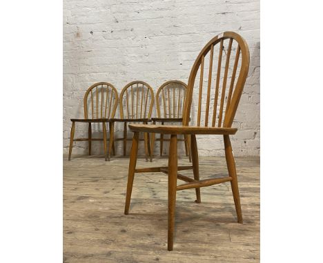 Ercol, A set of four beech and elm dining chairs, hoop and spindle backs, saddle seats, raised on turned supports, circa 1960