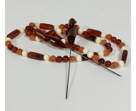 An amber, lozenge and bead alternating necklace, (39cm) with white plastic bead spacers and a pair of dark amber spiral twist