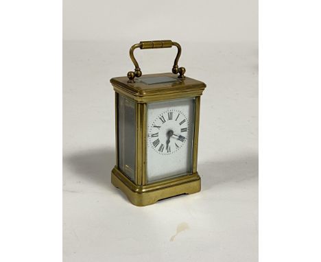 A miniature brass carriage time piece clock, first half of the 20th century, the case with swing handle over bevelled glass t